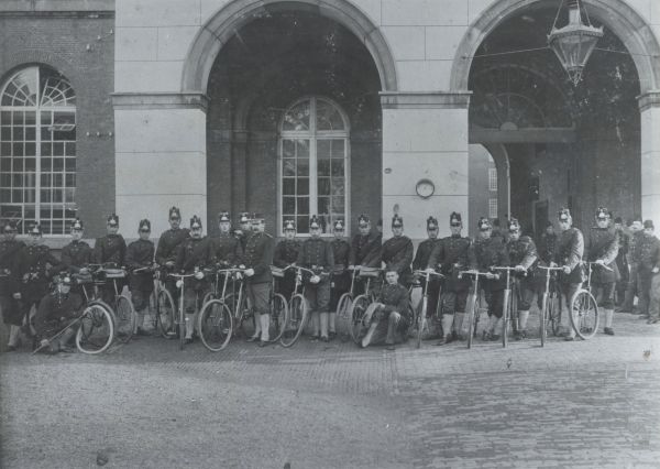 Grenadiers en Jagers met de fiets aan de hand op het voorplein van de Oranjekazerne in Den Haag. Foto Beeldbank NIMH